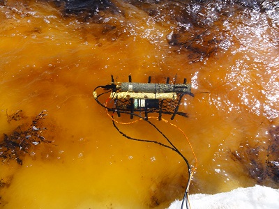 Measuring instrument in orange colored water in river